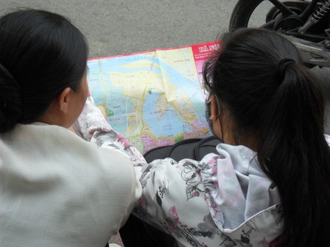 Hai mẹ con sĩ tử xem bản đồ để tìm đường về nhà người thân ở Hà Nội.